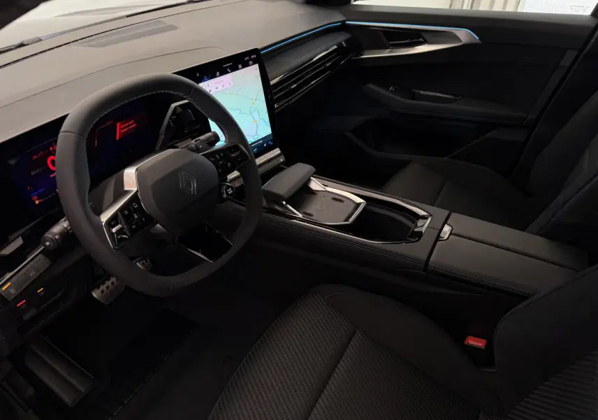 Intérieur noir du Renault Espace 2025 esprit Alpine, vue côté conducteur avec écran tactile central et volant cuir-suède.