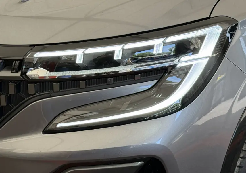 Gros plan sur le phare avant droit LED du Renault Espace esprit Alpine gris foncé, soulignant son design moderne et lumineux.