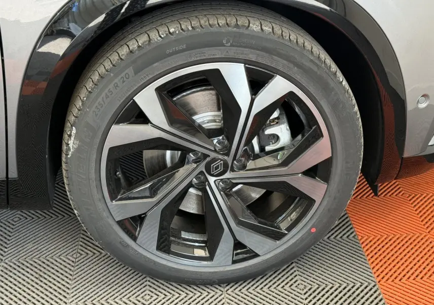 Gros plan sur la roue avant droite du Renault Espace gris foncé, mettant en valeur la jante alliage noire et argentée au design moderne.