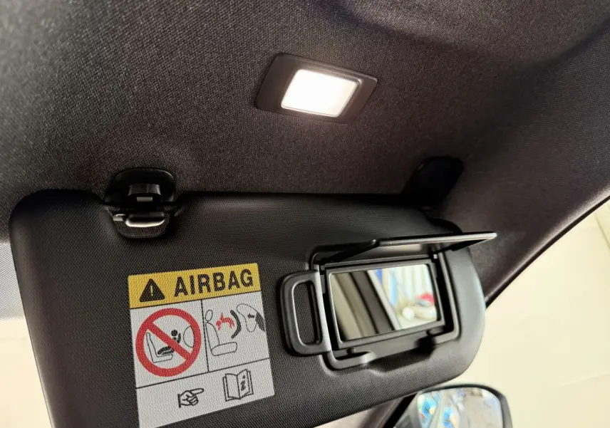 Détail du pare-soleil intérieur avec miroir et avertissement airbag dans un Renault Espace gris foncé 2025.