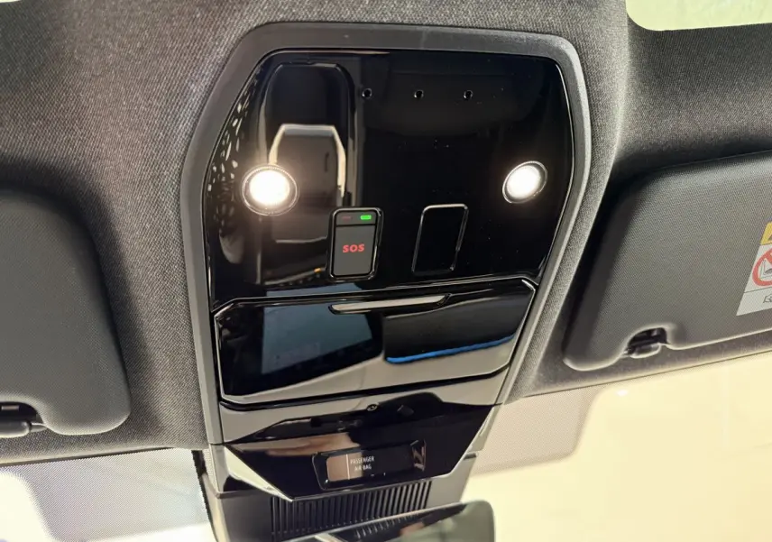 Vue en contre-plongée du plafonnier noir brillant avec bouton SOS et éclairages intégrés dans un Renault Espace gris foncé.