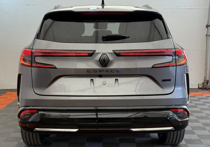 Vue arrière du Renault Espace gris foncé 2025 esprit Alpine hybride avec feux LED étirés et logo central visible.