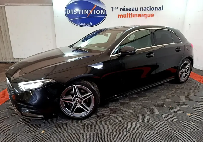 Mercedes Classe A 180 AMG Line noire vue de profil côté gauche, avec jantes alliage à cinq branches et phares LED allumés.