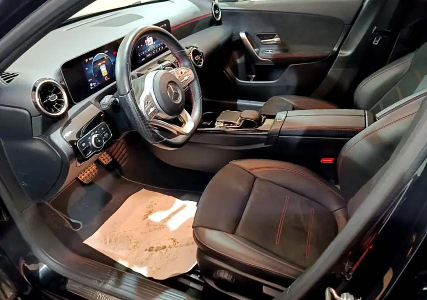 Intérieur noir de la Mercedes Classe A 180 AMG Line 2019 vu côté conducteur, volant cuir et tableau de bord digital.