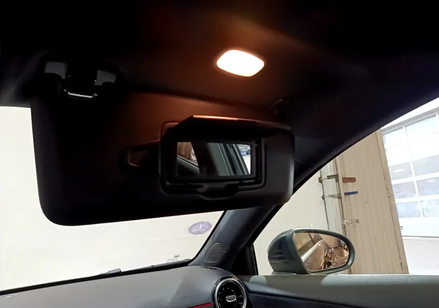 Intérieur noir de la Mercedes Classe A 180 AMG Line 2019, vue sur pare-soleil avec miroir et rétro côté droit.