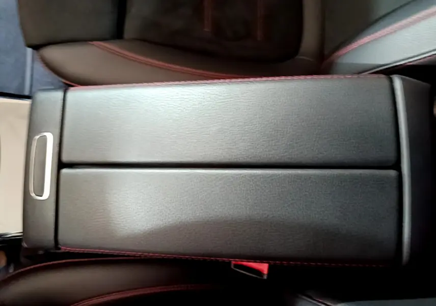 Gros plan sur l'accoudoir central en cuir noir avec surpiqûres rouges de la Mercedes Classe A 180 AMG Line 2019.