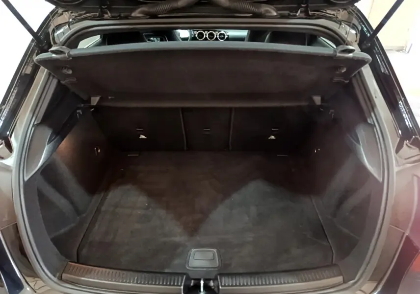 Coffre ouvert noir de la Mercedes Classe A 180 AMG Line 2019, vue arrière montrant l'espace de chargement vide.