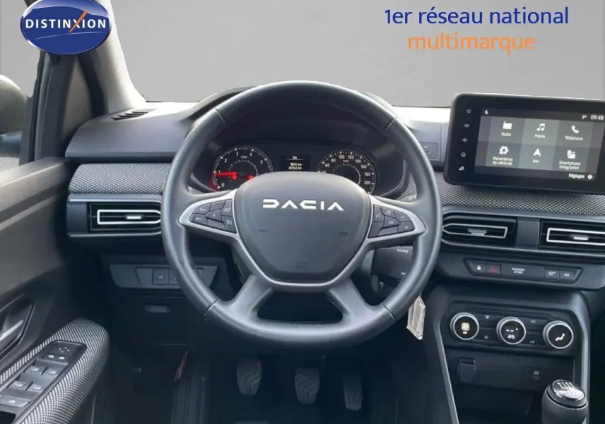 Vue intérieure centrée sur le volant DACIA d’un Jogger 2025, avec tableau de bord et écran tactile visibles.