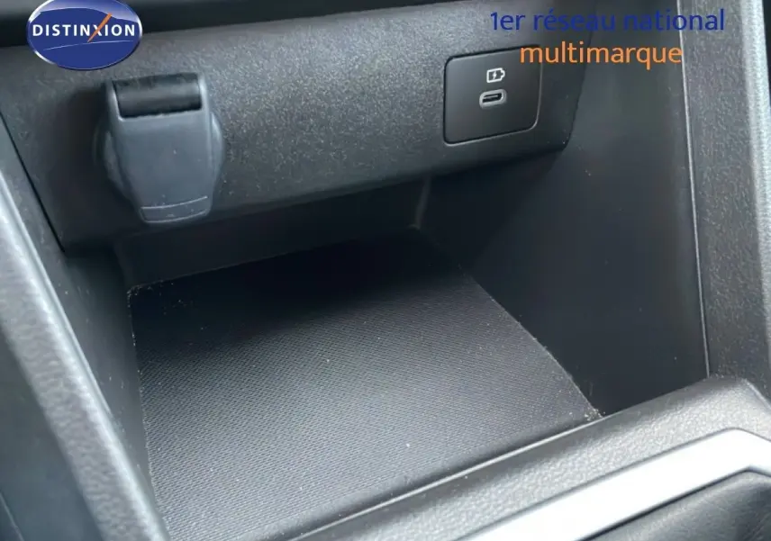 Gros plan sur la prise USB et l’allume-cigare dans le rangement intérieur du Dacia Jogger gris schiste métal.