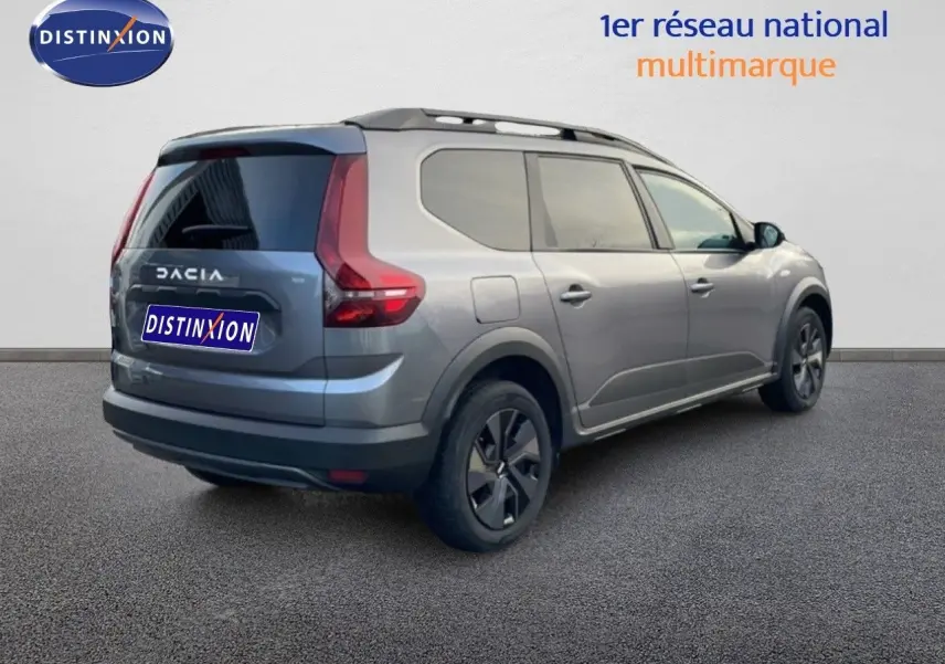 Vue 3/4 arrière droite du Dacia Jogger gris schiste métal avec feux arrière en forme de L et toit noir.