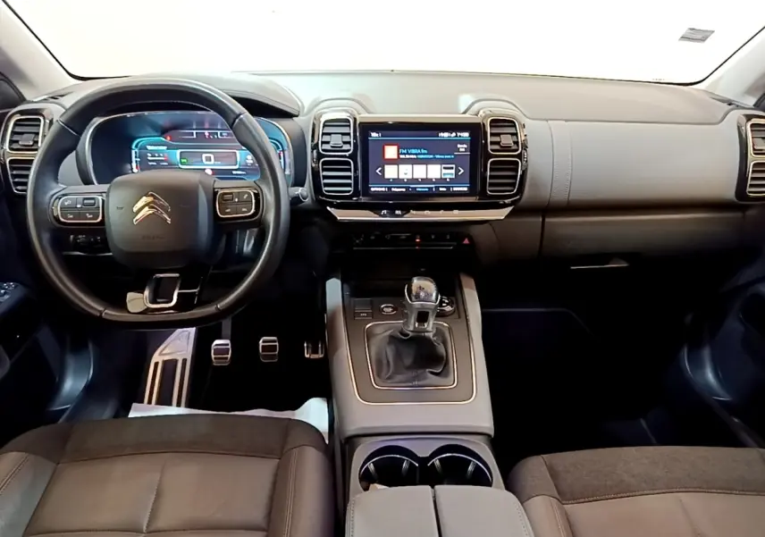 Vue intérieure avant du Citroën C5 Aircross gris foncé, volant cuir multifonctions et écran tactile central visible.