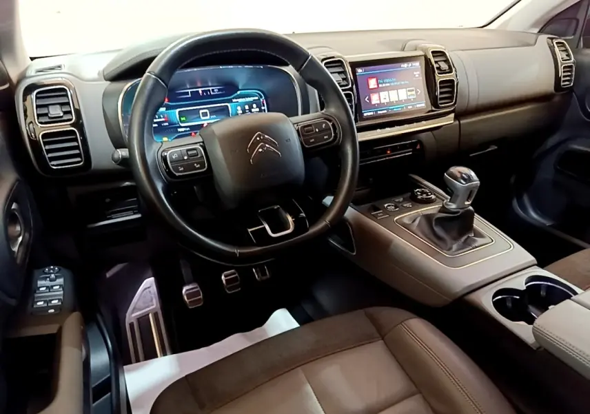 Intérieur de Citroën C5 Aircross gris foncé, vue côté conducteur sur volant cuir et console centrale avec boîte manuelle.