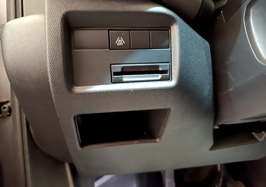 Détail intérieur côté gauche sous le tableau de bord du Citroën C5 Aircross 2020, avec bouton de désactivation d’aide à la conduite.