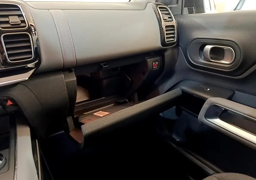 Intérieur du Citroën C5 Aircross 2020, vue côté passager avec boîte à gants ouverte et tableau de bord gris foncé.