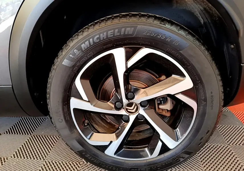 Gros plan sur la roue avant droite du Citroën C5 Aircross gris foncé, avec jante alliage bicolore et pneu Michelin.