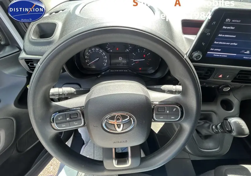 Vue intérieure centrée sur le volant noir du Toyota Proace City 2023 avec tableau de bord et levier de vitesses manuel.