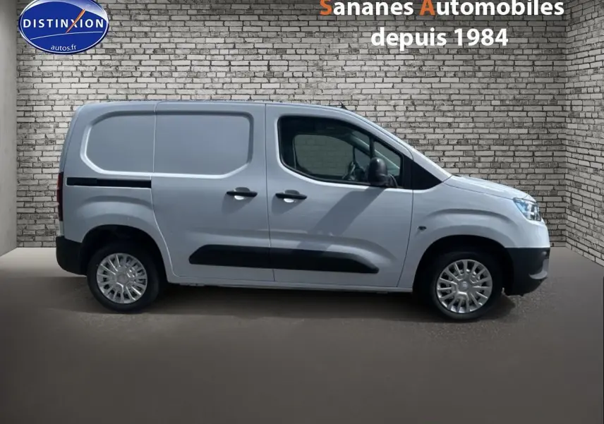 Vue de profil côté gauche du Toyota Proace City blanc 2023 avec porte latérale tôlée et coques de rétroviseurs noires.