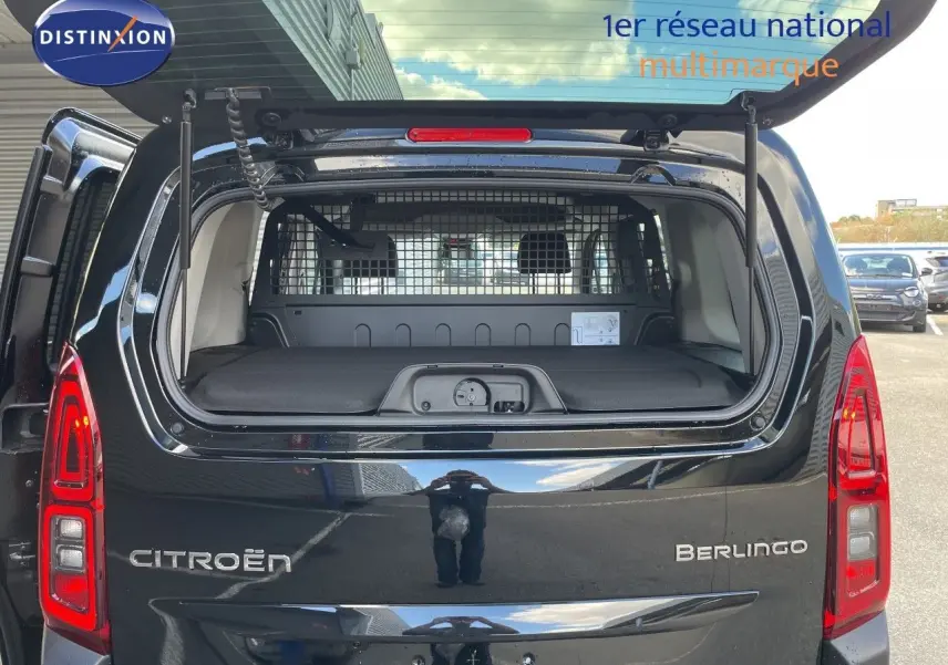 Vue arrière du Citroën Berlingo noir Perla Nera avec hayon ouvert, montrant l'espace de chargement et la grille de séparation.