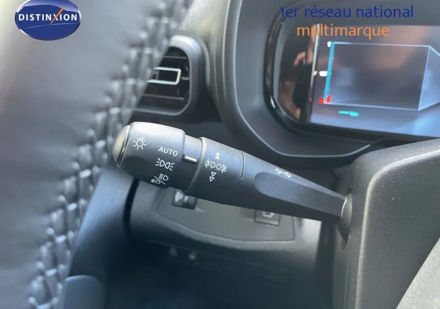 Gros plan sur la commande des feux et clignotants à gauche du volant dans un Citroën Berlingo noir Perla Nera 2026.