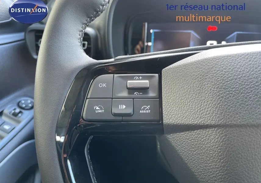 Gros plan sur le volant noir du Citroën Berlingo 2026, avec commandes intégrées côté gauche et tableau de bord en arrière-plan.