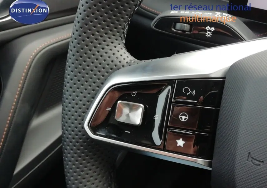 Gros plan sur les commandes du volant en cuir perforé noir du MG MOTOR EHS 1.5T PHEV 272CH LUXURY, intérieur noir.