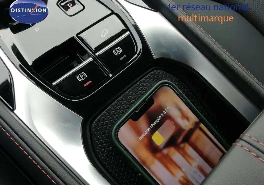 Gros plan sur la console centrale du MG MOTOR EHS 1.5T PHEV 272CH Luxury avec téléphone en charge sans fil.