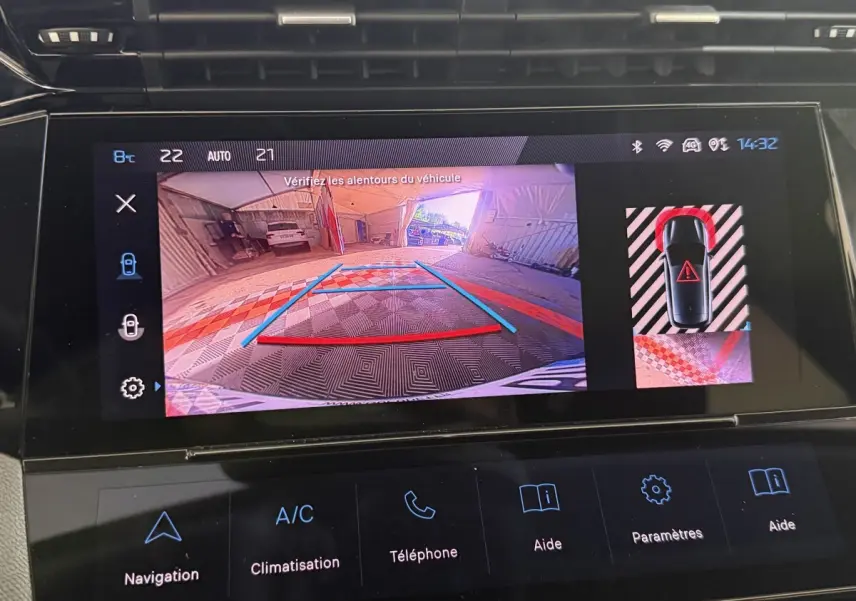Écran tactile de la Peugeot 308 bleu montrant la caméra de recul et l’aide au stationnement arrière en intérieur.