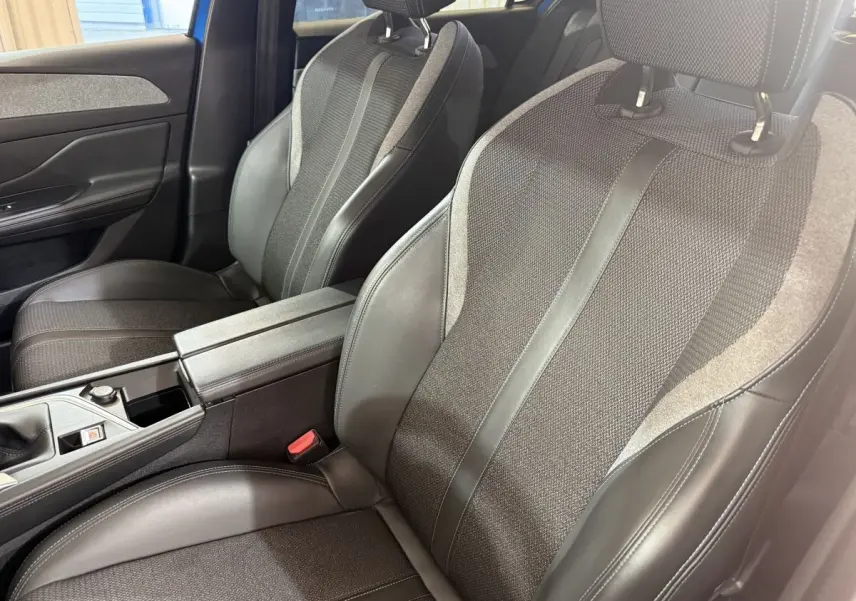Vue rapprochée des sièges avant en tissu et cuir noir de la Peugeot 308 PureTech 130 S&S Allure Pack 2023.