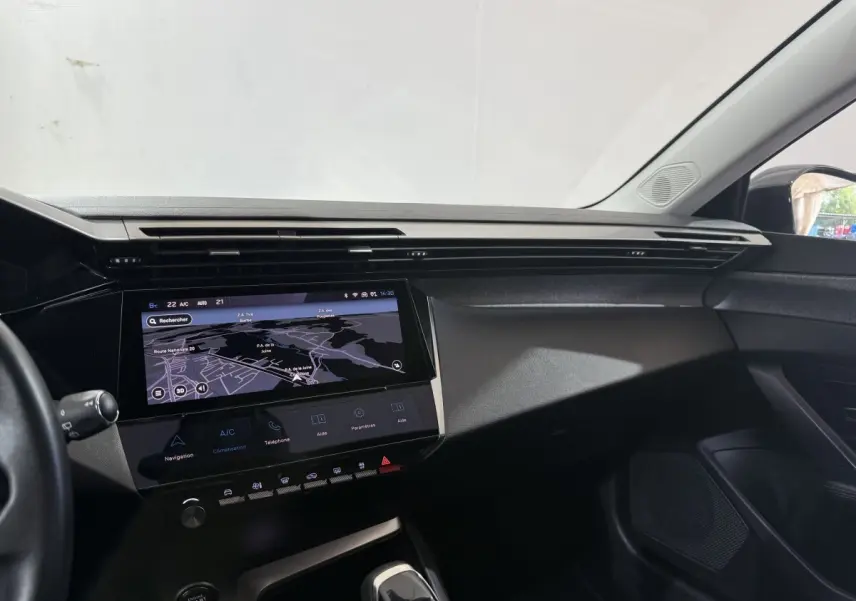 Vue intérieure côté passager du tableau de bord noir avec écran tactile de navigation de la Peugeot 308 bleu 2023 PureTech.