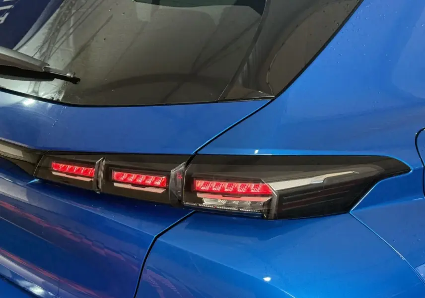 Feu arrière droit allumé d'une Peugeot 308 bleu 2023, vue rapprochée sur la partie arrière droite.