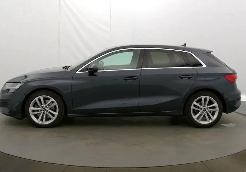 Profil côté gauche d'une Audi A3 Sportback 2021 gris Manhattan avec jantes alliage et vitres teintées.