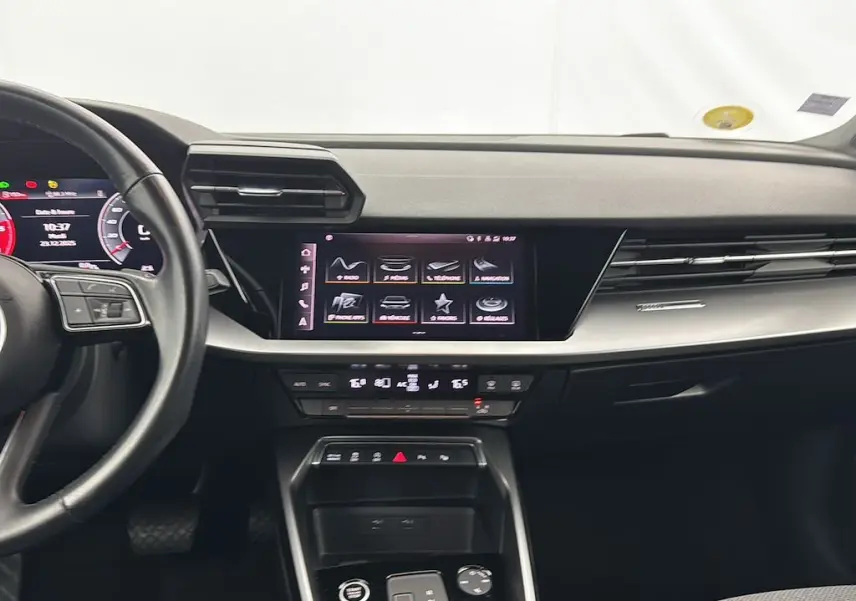 Vue intérieure de l'Audi A3 Sportback 2021, tableau de bord avec écran tactile central et volant partiel à gauche.