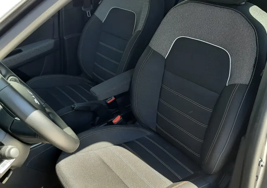 Vue intérieure côté conducteur des sièges avant en tissu gris et noir de la Dacia Sandero Stepway 2025.