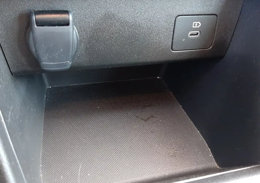 Détail de la console centrale de la Dacia Sandero Stepway 2025, prise de courant et port USB visible sur fond noir.