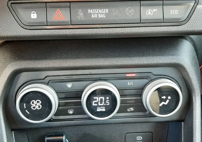 Détail de la console centrale de la Dacia Sandero Stepway 2025, montrant les commandes de climatisation et les boutons de sécurité.