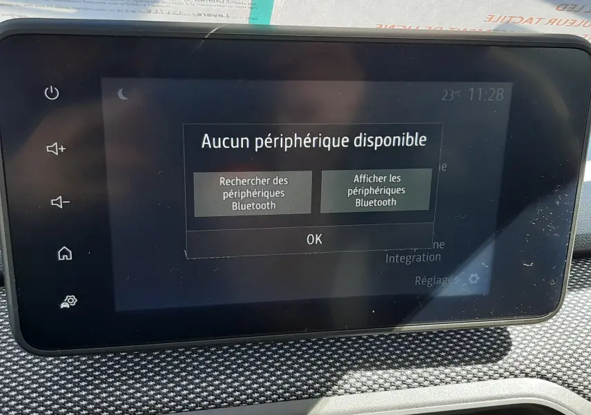 Écran tactile central de la Dacia Sandero Stepway 2025 affichant un message Bluetooth, entouré de la console avec aérateurs noirs et orange.