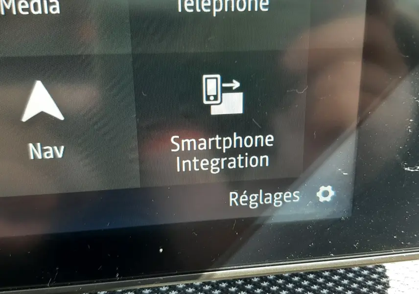 Écran tactile intérieur du Dacia Sandero Stepway 2025 montrant l'option Smartphone Integration avec fond gris et texte blanc.