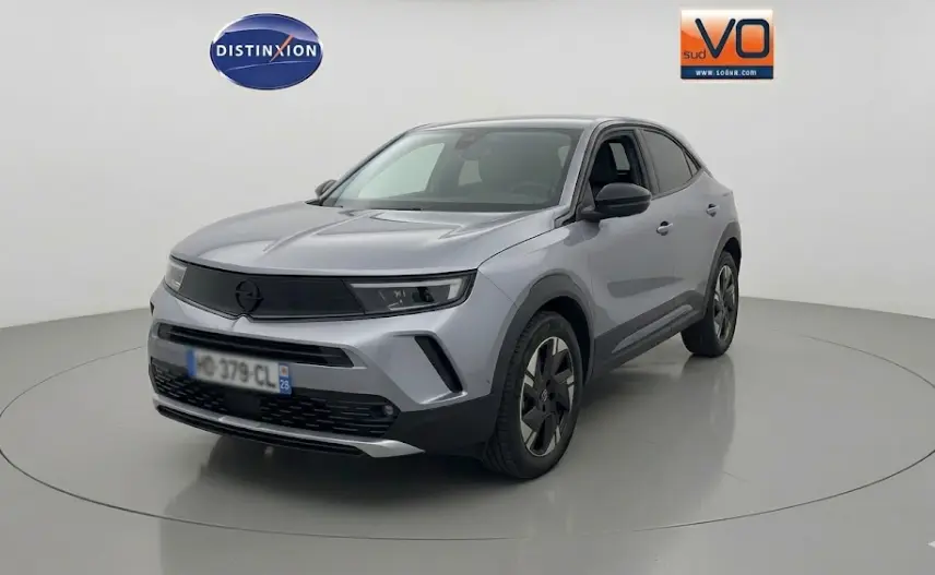 Opel Mokka électrique gris en 3/4 avant droit, avec jantes alliage 17 pouces et vitres surteintées.