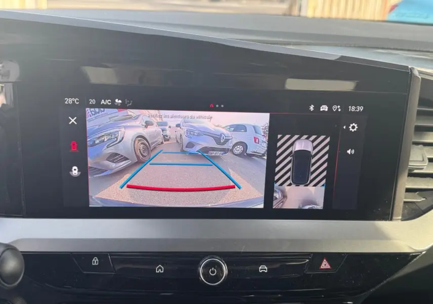 Écran tactile intérieur montrant la caméra de recul avec vue arrière sur une Opel Mokka grise en stationnement.