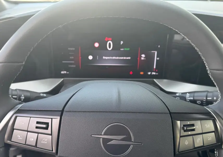 Vue intérieure centrée sur le volant noir de l'Opel Mokka électrique 2025 avec tableau de bord numérique allumé.