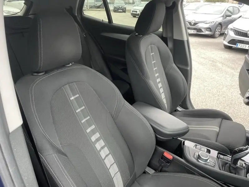 Vue intérieure des sièges avant noirs avec surpiqûres grises d'une BMW X2 X-Drive 20 da 2021, côté conducteur et passager.