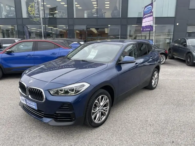 BMW X2 X-Drive 20 da bleu métal vue 3/4 avant droit, avec jantes alliage et calandre caractéristique 2021.