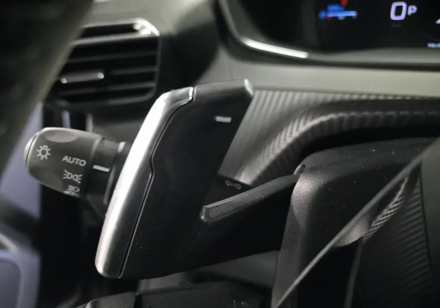 Gros plan sur la palette de commande de boîte automatique noire avec insert argent dans l’habitacle du Peugeot 2008 noir.