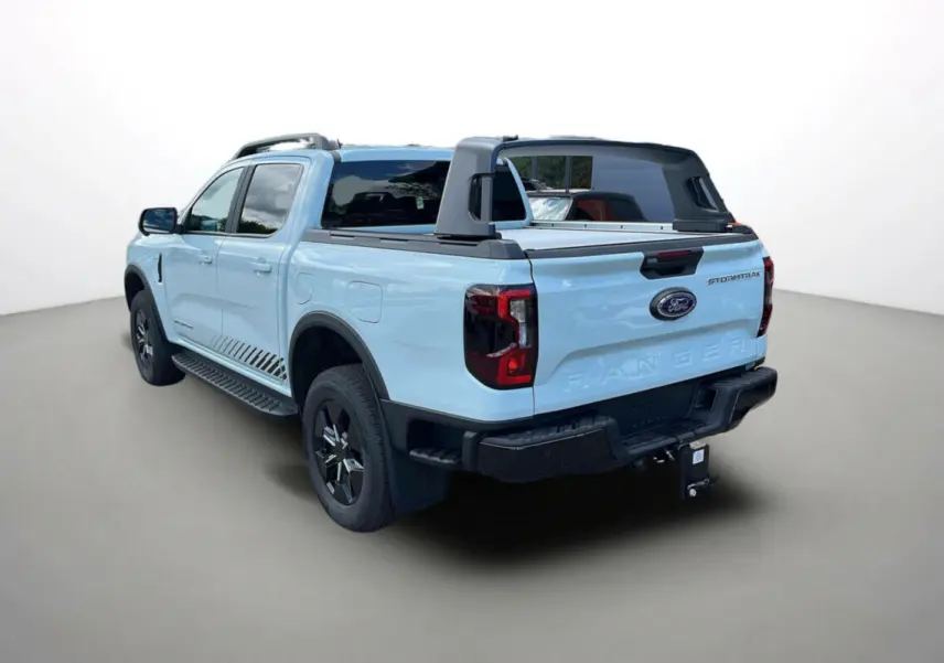 Ford Ranger Stormtrak 2026 vue 3/4 arrière droit, couleur bleu clair avec arceau sport et attelage visible.