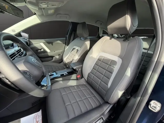 Intérieur de la Citroën C4 hybride bleu, vue côté conducteur, sièges tissu gris avec volant cuir multifonctions.
