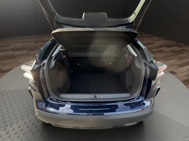 Coffre ouvert vu de l'arrière d'une Citroën C4 hybride 2025 bleu, avec hayon et espace de chargement visible.