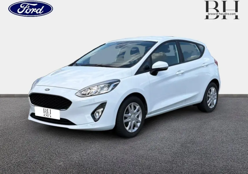 Ford Fiesta blanc glacier vue 3/4 avant droit, avec calandre noire et jantes argentées.
