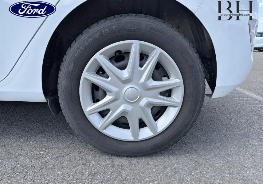 Gros plan sur la roue arrière droite d'une Ford Fiesta blanche Glacier avec enjoliveur d'origine et pneu noir.