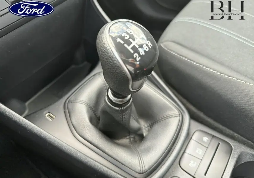 Gros plan sur le levier de vitesses manuel noir et la console centrale d’une Ford Fiesta 2020 avec sièges tissu gris.
