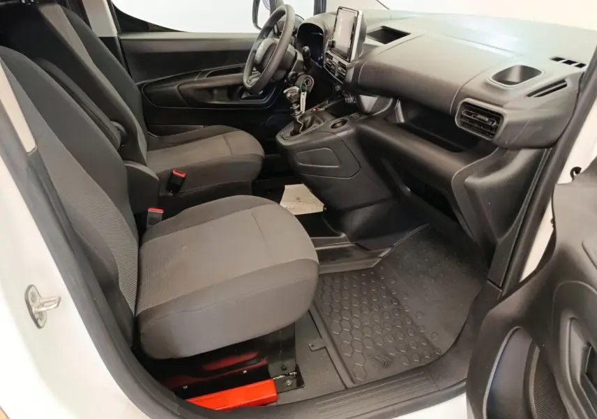 Vue intérieure côté conducteur du Citroën Berlingo blanc 2022, montrant sièges avant et tableau de bord noir.